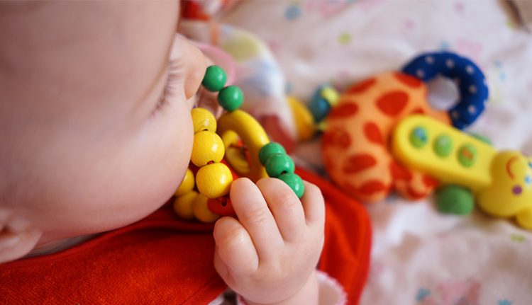 baby chewing on toy